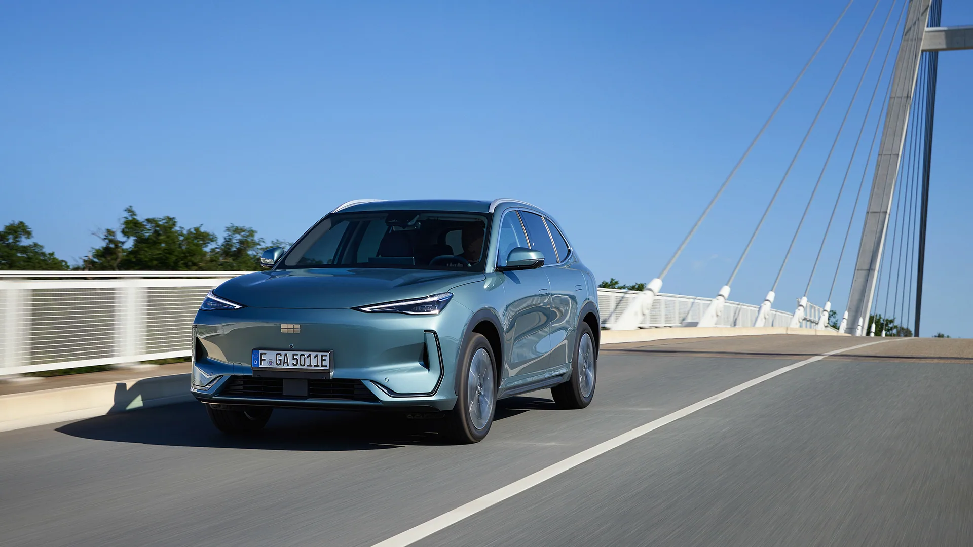 Türkisgrüner Geely E5 auf einer Schrägseilbrücke